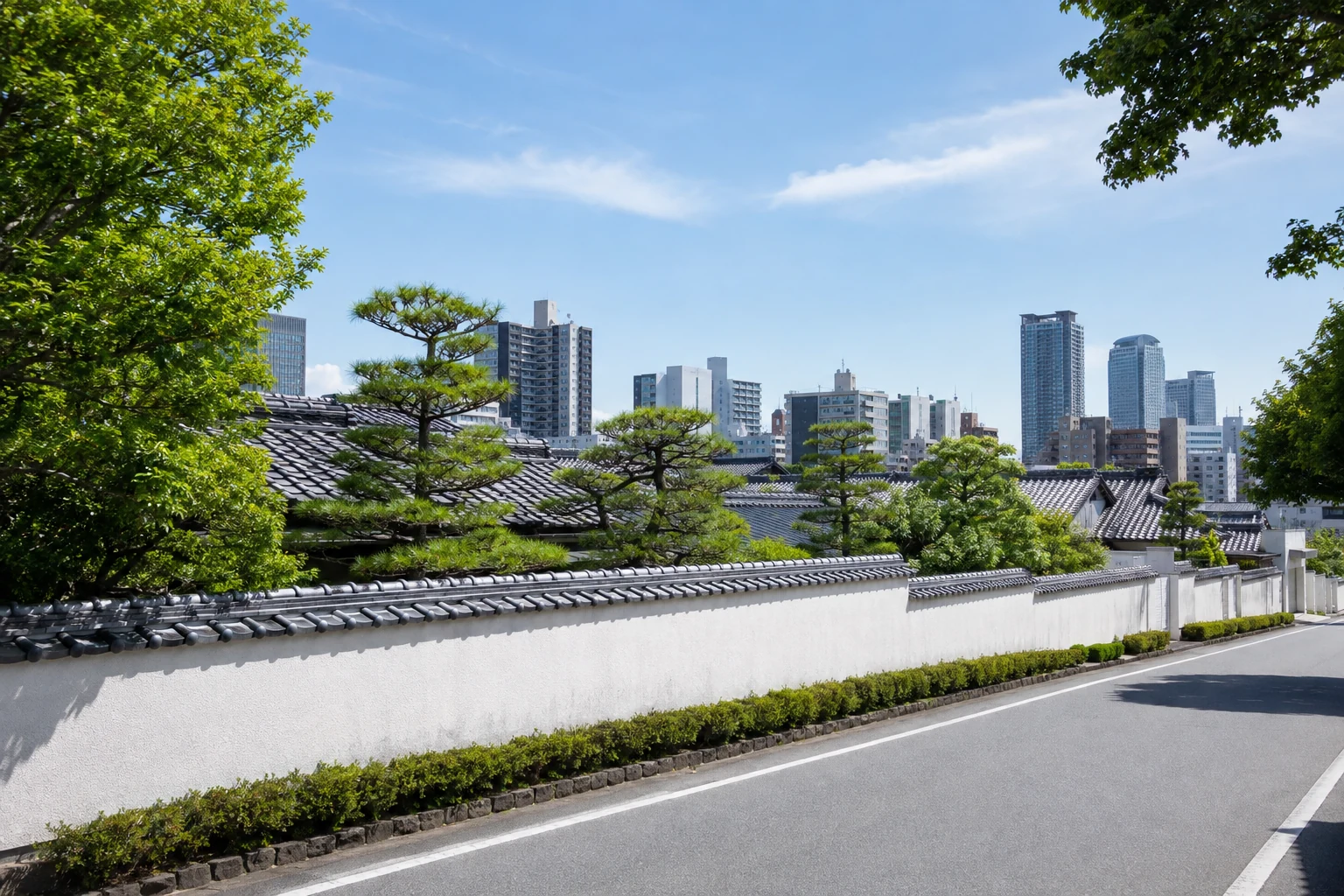 Wohnstraße in Higashi-ku mit weißen Mauern, japanischen Ziegeldächern und moderner Nagoyaer Stadtsilhouette
